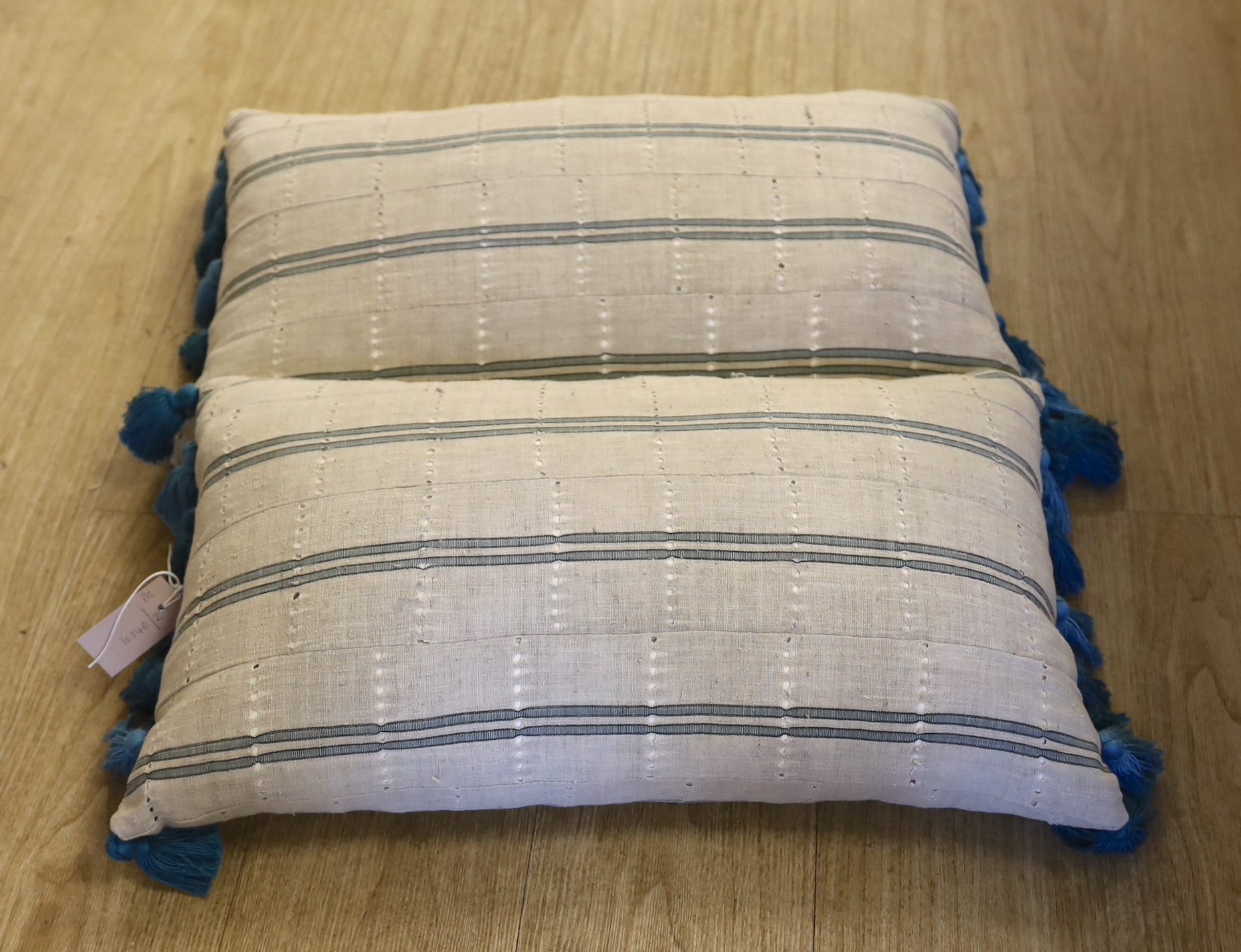 A pair of vintage Yoruba cushions with bamboo tassels, each 65cm wide